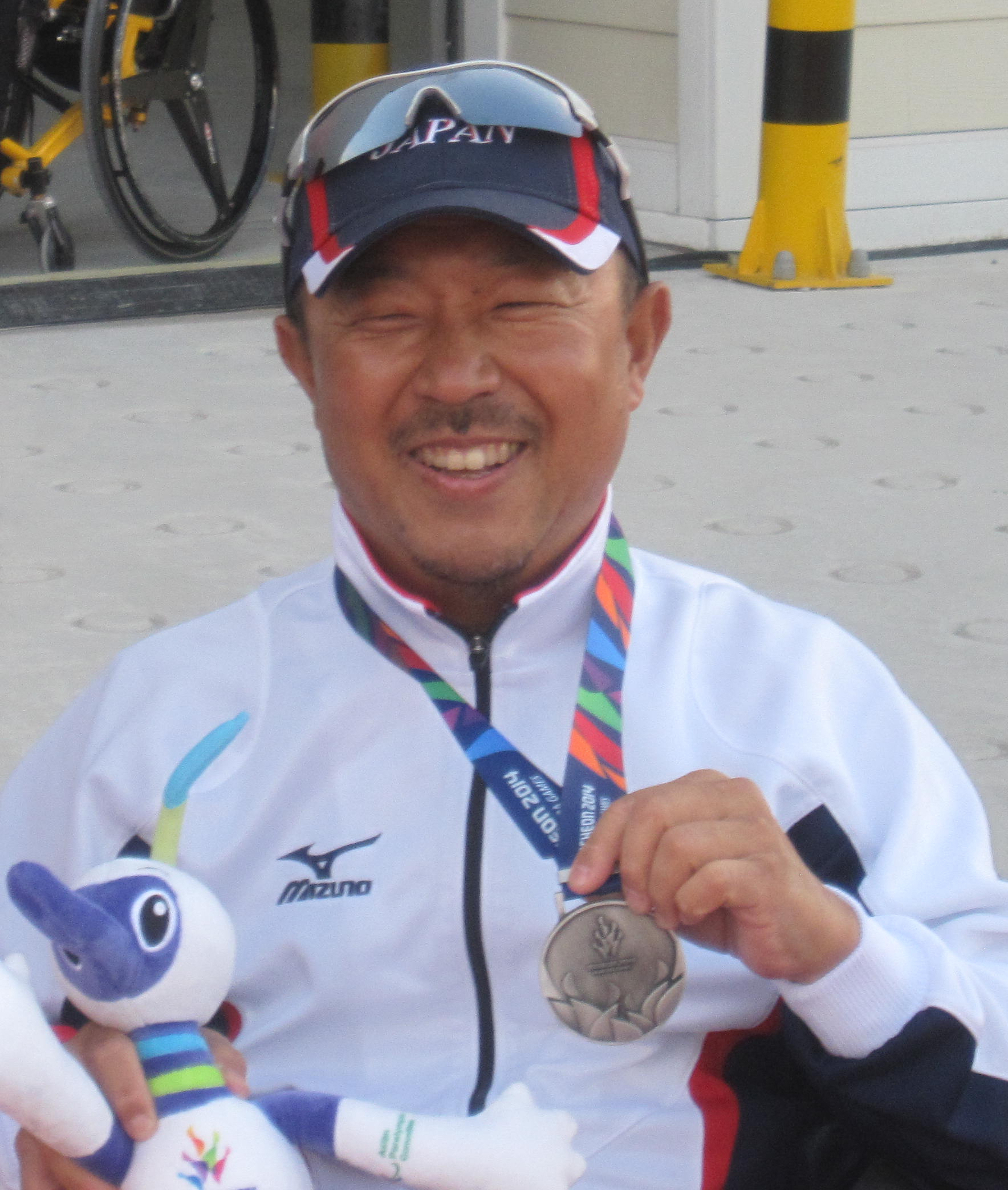 写真:アジア大会の銀メダルとマスコットを手にした山本真也が記念撮影している様子