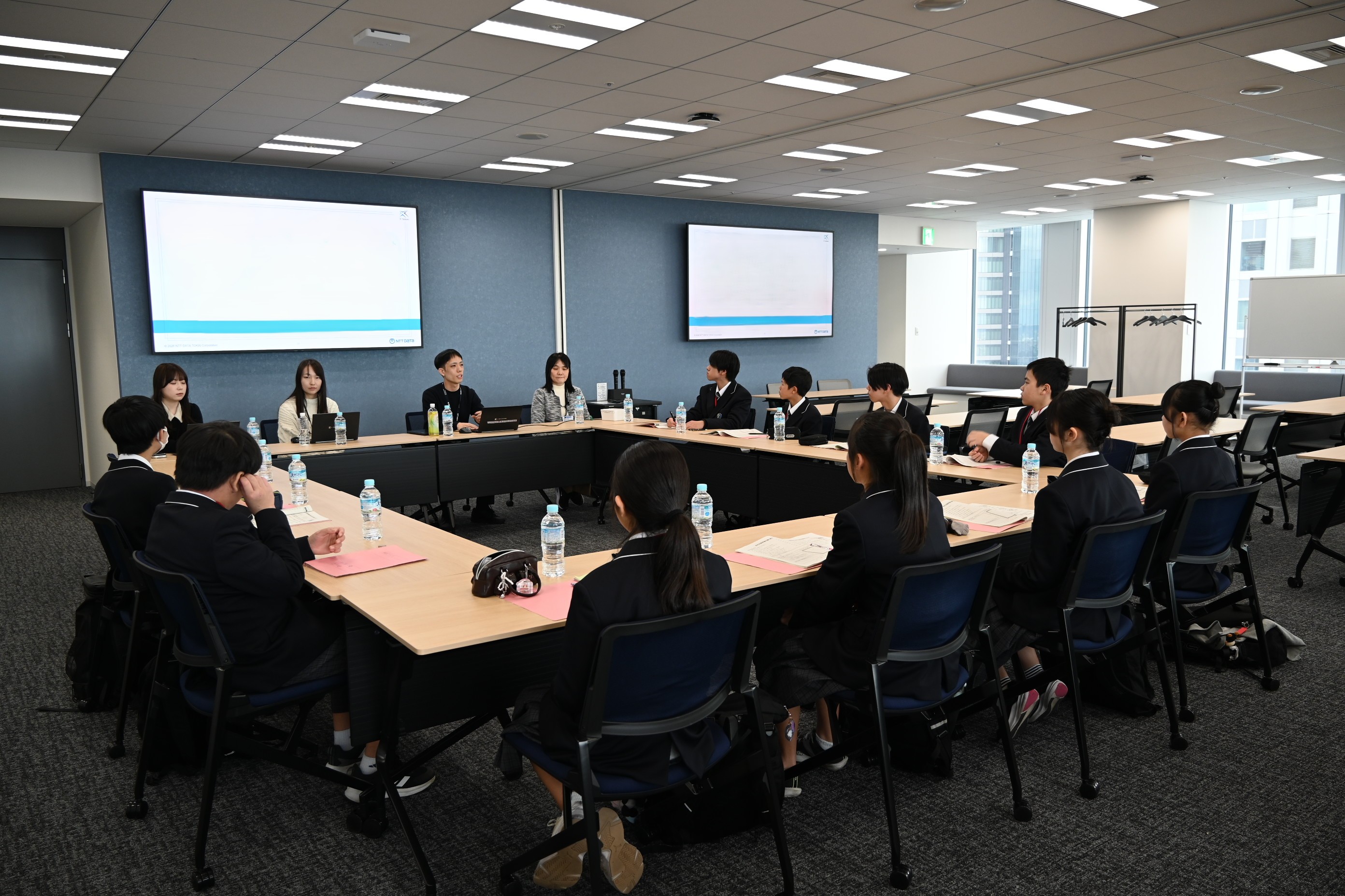 写真：会議室で生徒と若手社員が向かい合い意見交換をしている様子